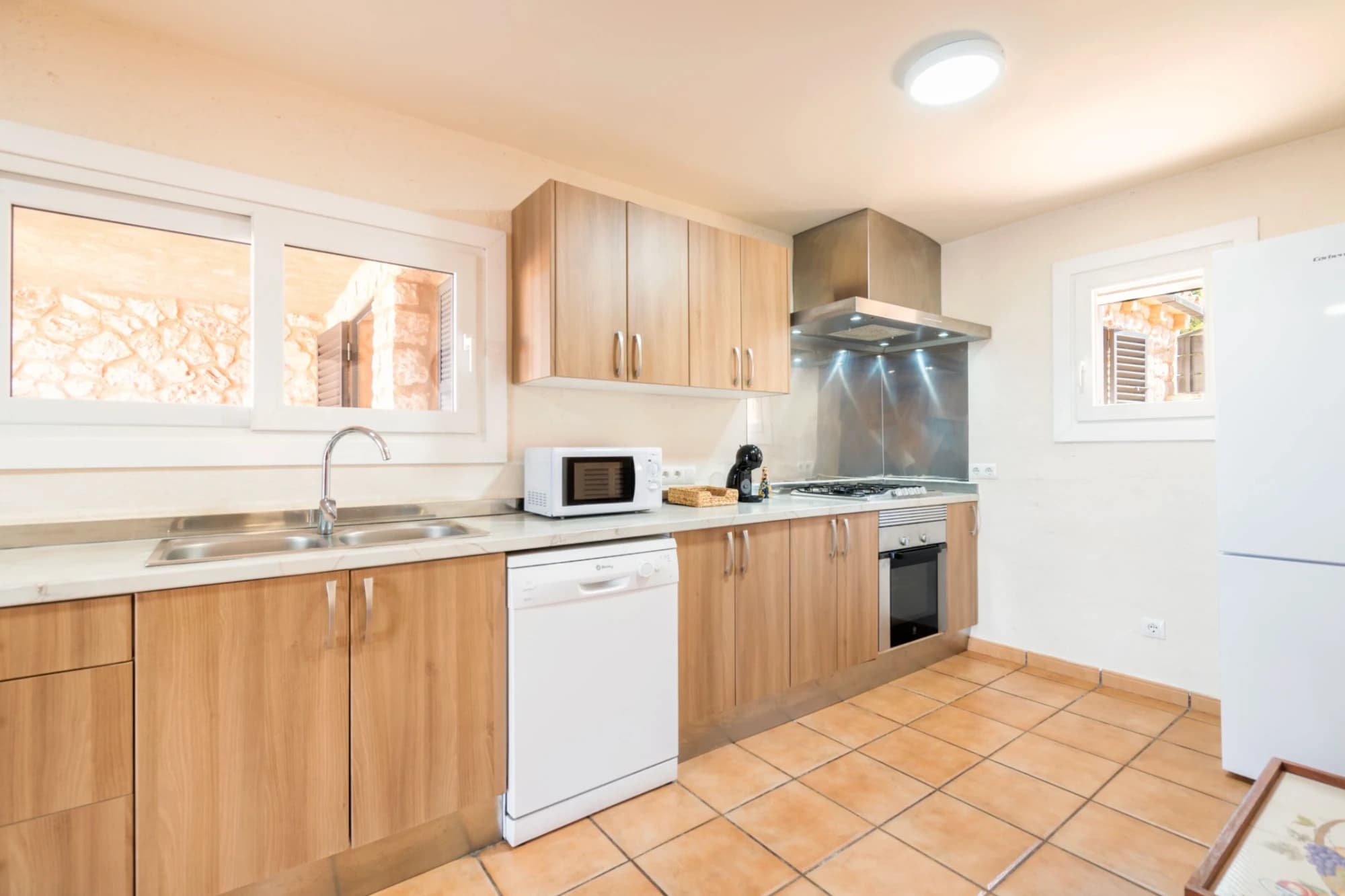A kitchen with wooden cabinets, a microwave, a dishwasher, and a stove.
